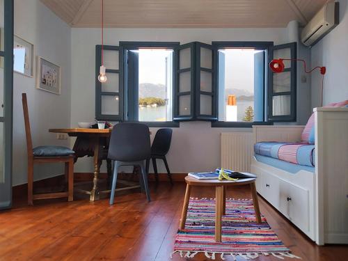 a room with a bed and a table and a desk at Anemone Residence in Poros