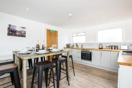 a kitchen with a table and some stools in it at Liverpool Waterfront Stay, excellent location , parking available in Liverpool