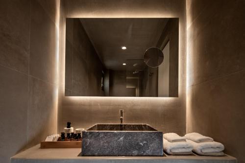 La salle de bains est pourvue d'un lavabo et d'un miroir. dans l'établissement Colombos Beachfront, à Foinikiá