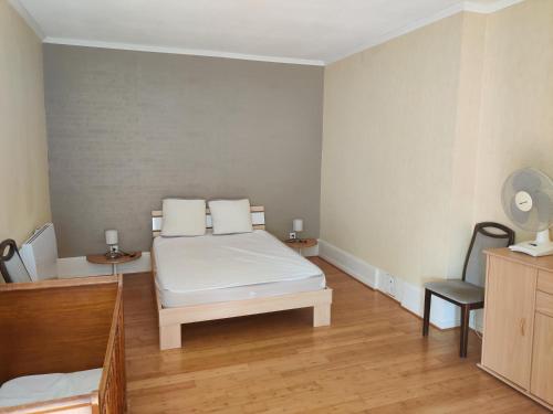 una camera con un letto bianco e una sedia di Villa Spetz a Issenheim