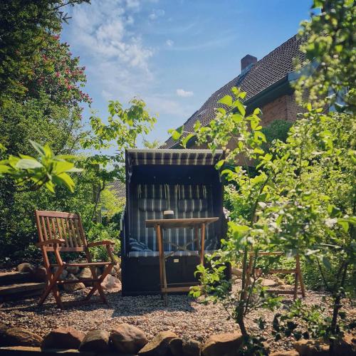 a garden with two chairs and a table and a bench at Kieler Eiderparadies in Flintbek