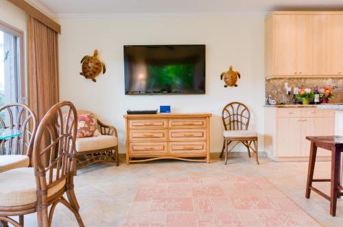 a living room with a tv on a wall at Hale Napili in Lahaina