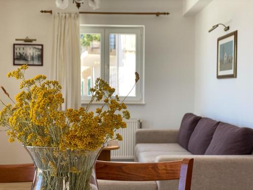 a vase with yellow flowers in a living room at Villa Adria in Vodice