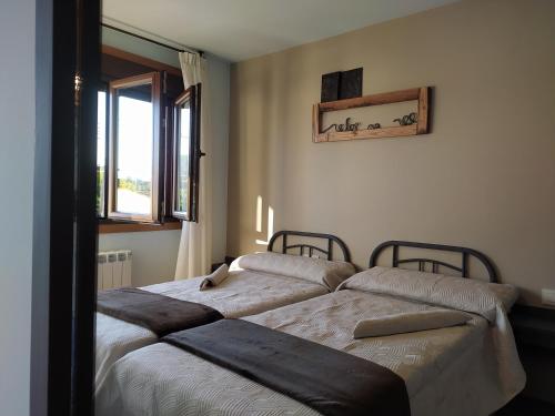 a bedroom with two beds and a window at Casa das Pozas 2 in Monforte de Lemos