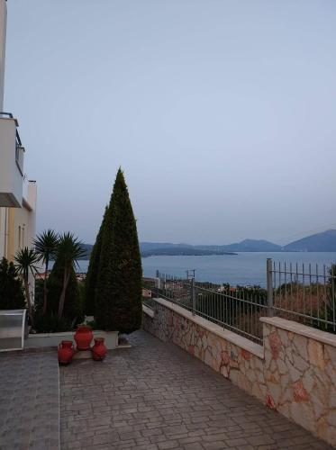 a brick walkway with a view of the water at Villa Christine - Maisonettes with fireplace in Aliveri