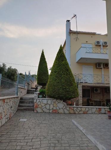 a group of trees in front of a building at Villa Christine - Maisonettes with fireplace in Aliveri