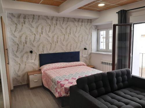 1 dormitorio con 1 cama y 1 sofá en Estudio Morella, en Morella