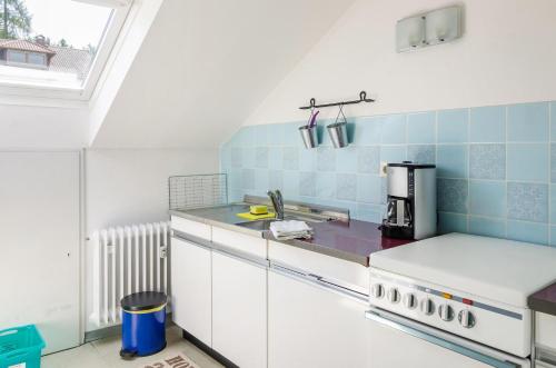 a kitchen with blue and white tiles on the wall at Ferienwohnung Säntisblick in Daisendorf