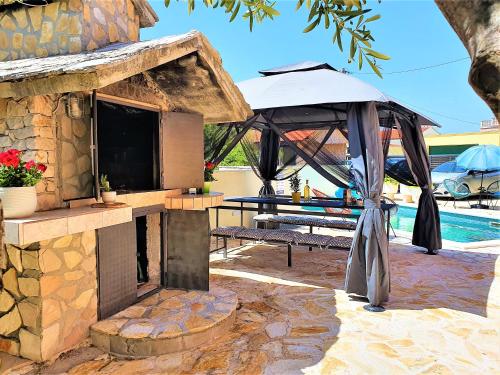 a patio with an umbrella and a table and a pool at Villa Spark with heated pool in Rogoznica Zecevo in Zečevo Rogozničko