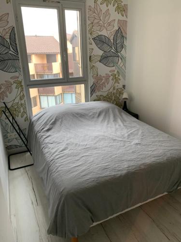 a bed in a room with a window at Appartement vue sur mer, 30m de la plage in Lacanau-Océan