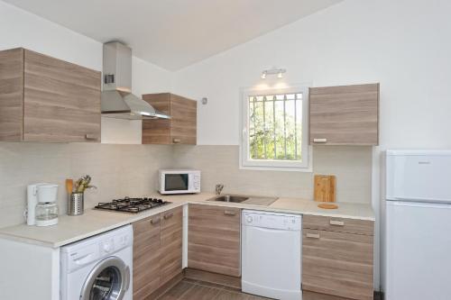 a kitchen with a white refrigerator and a stove top oven at Domaine de Pianiccia in Sari Solenzara