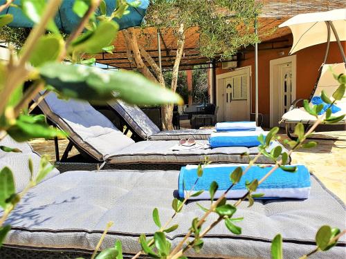 a group of beds and umbrellas on a patio at Villa Spark with heated pool in Rogoznica Zecevo in Zečevo Rogozničko