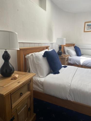 a bedroom with two beds and a table with two lamps at The Tudor Hotel in Bridgwater