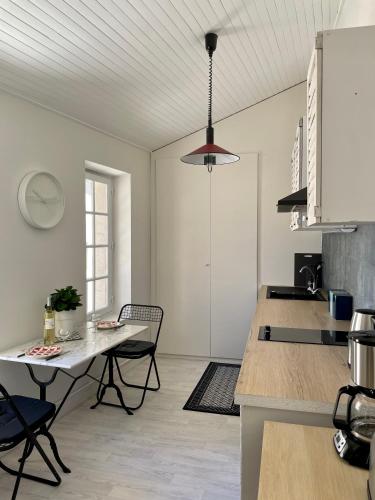une cuisine avec une table et des chaises dans une pièce dans l'établissement Appartement aux pieds du Palais des Papes., à Avignon
