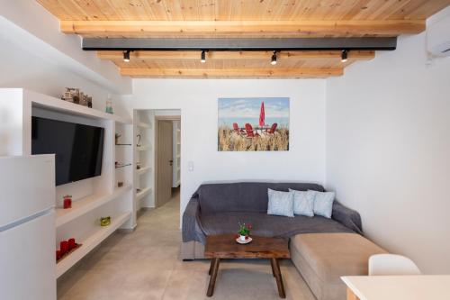a living room with a couch and a tv at Blue View Villa Apartment #3 With Jacuzzi in Parasporos