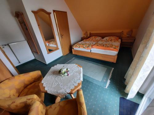 einen Blick über ein Schlafzimmer mit einem Bett und einem Tisch in der Unterkunft Landpension Rödigsdorf in Rödigsdorf