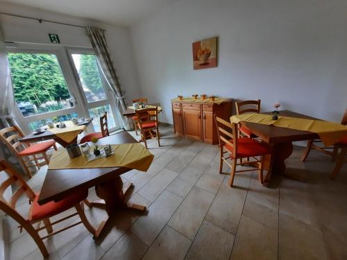 ein Restaurant mit Tischen und Stühlen in einem Zimmer in der Unterkunft Landpension Rödigsdorf in Rödigsdorf
