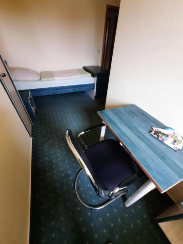 a desk and a chair in a room with a bed at Landpension Rödigsdorf in Rödigsdorf