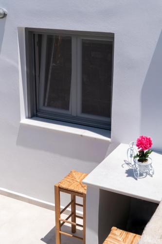 a vase of flowers on a table in front of a window at Blue View Villa Apartment #3 With Jacuzzi in Parasporos