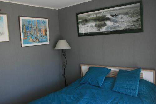 a bedroom with a blue bed and pictures on the wall at Chambre avec accès piscine intérieure in Larmor-Plage