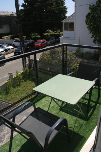 a white table and chairs on a balcony at Chambre avec accès piscine intérieure in Larmor-Plage