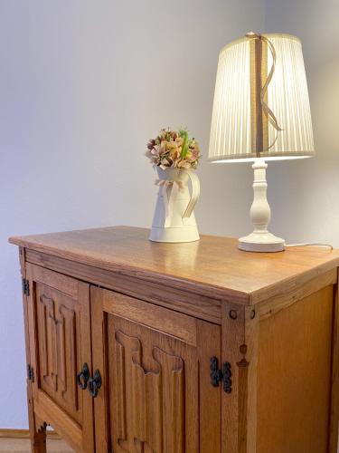 a table with a lamp and a vase with flowers on it at Villa Adria in Vodice