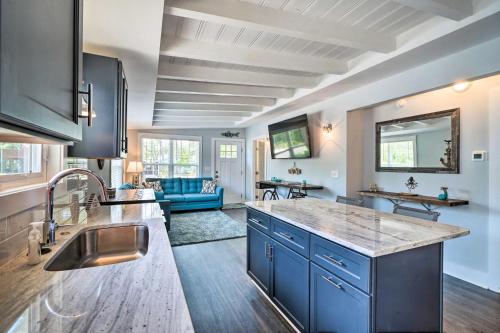 a kitchen with blue cabinets and a living room at Modern Oak Island Escape 1 Mile to Long Beach! in Oak Island