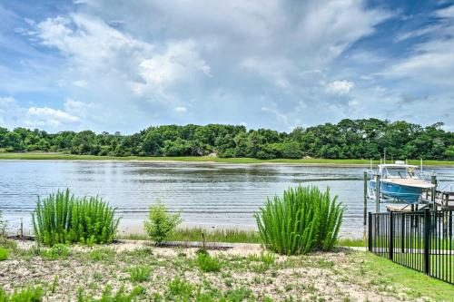 a boat is docked on the shore of a lake at Modern Oak Island Escape 1 Mile to Long Beach! in Oak Island