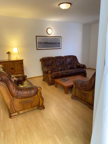 a living room with brown leather couches and a table at Villa Adria in Vodice