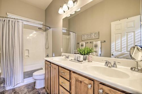 une salle de bain avec un lavabo, des toilettes et une douche dans l'établissement Game Room and Pool Stylish Goodyear Home!, à Liberty