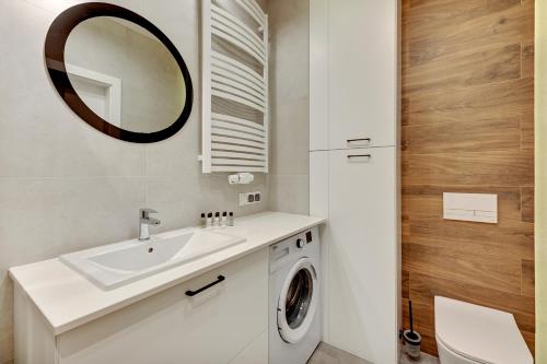 a bathroom with a sink and a washing machine at Dom & House - Apartments Nadmorski Park in Gdańsk