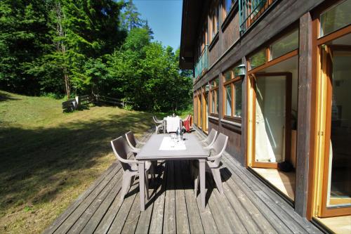a wooden deck with a table and chairs on it at Bad Kleinkirchheim RMG family apartments in Bad Kleinkirchheim