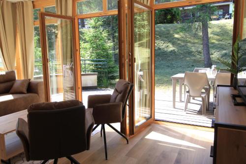 a room with glass doors and a table and chairs at Bad Kleinkirchheim RMG family apartments in Bad Kleinkirchheim
