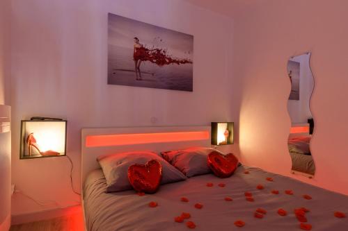 a bedroom with a bed with red roses on it at Love Room - Suite romantique avec spa privatif in Le Puy en Velay