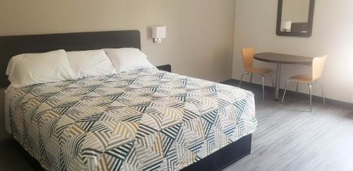 a bedroom with a bed and a table with chairs at Motel 6 Mobile, AL - Airport Blvd in Mobile