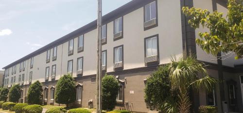 a large white building with a lot of windows at Motel 6 Mobile, AL - Airport Blvd in Mobile