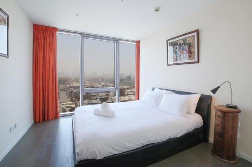 a bedroom with a large bed and a large window at D1 Tower - 2BR Apartment - Allsopp&Allsopp in Dubai