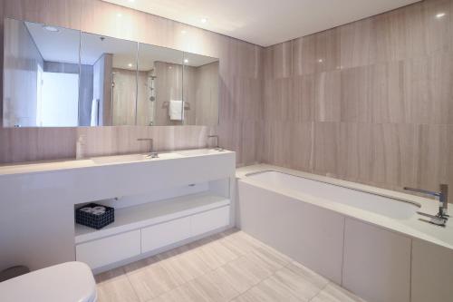 a bathroom with a tub and a sink and a toilet at D1 Tower - 2BR Apartment - Allsopp&Allsopp in Dubai