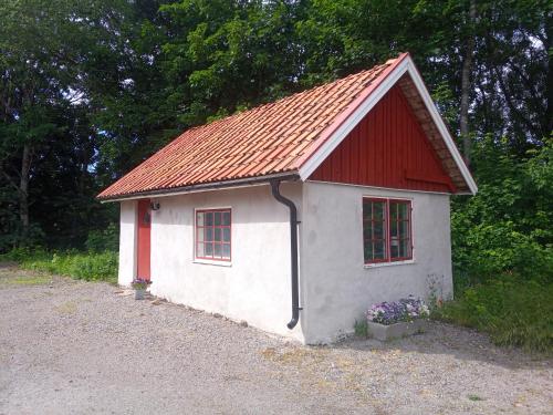 una pequeña casa con techo rojo en Sjögårdens gästhus med sovloft, en Floby