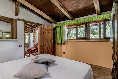 1 dormitorio con cama blanca y ventanas en Country House di Campo Stivaletto Nepi en Nepi