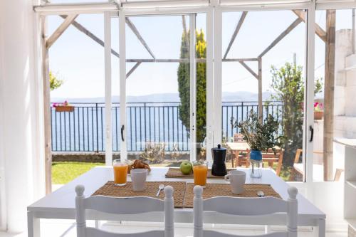 una mesa blanca con 2 sillas y bebidas en el balcón en Apartamentos Miramar Playa en Raxo
