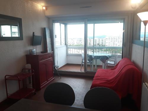 a room with a bed and a balcony with a table at Le Callisto 2 in Mauguio
