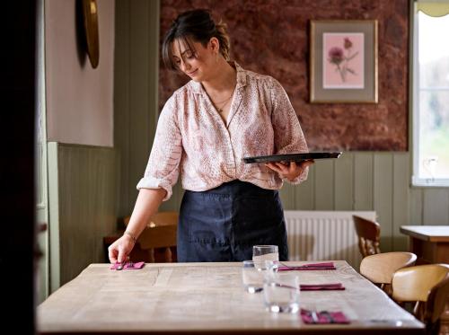 a woman standing at a table with a tablet at The Martlet Inn in Wellington