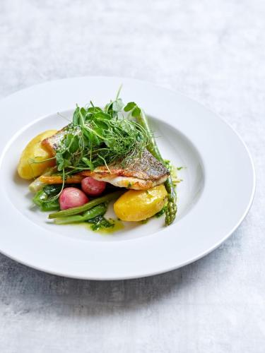 a white plate of food with fish and vegetables at The Martlet Inn in Wellington