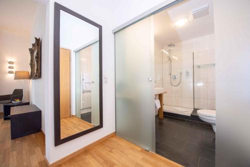 a bathroom with a large mirror and a toilet at Laudensacks Parkhotel & Retreat in Bad Kissingen