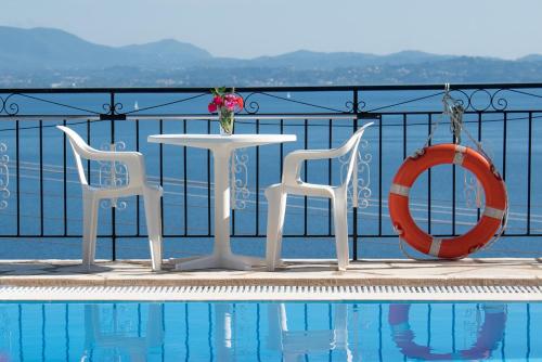 a table and two chairs next to a swimming pool at Amalia Complex in Nisakion