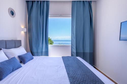 a bedroom with a bed and a large window at Anasa Corfu in Benitses