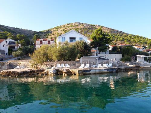a group of chairs sitting on a dock in the water at VILLA LAURA in Grebaštica
