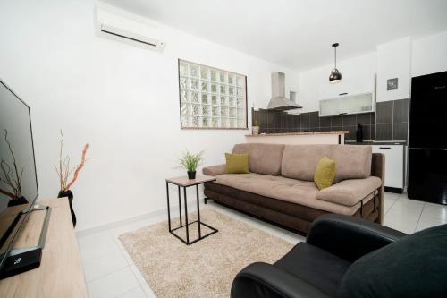 a living room with a couch and a kitchen at SUNSET APARTMENTS RABAC in Rabac