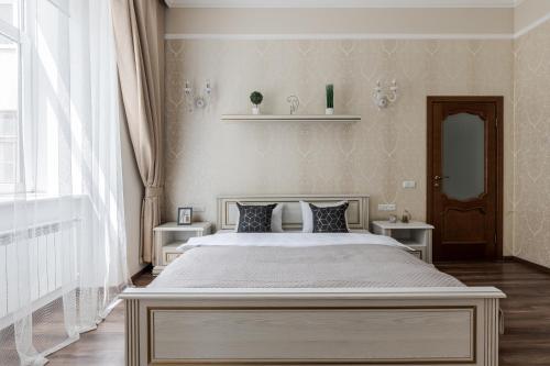 een slaapkamer met een groot bed en 2 tafels bij InshiApartments on Valova str in Lviv